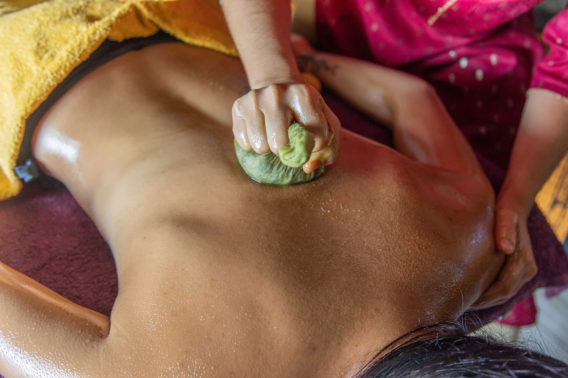 Massage thérapeutique avec ballotins de plantes et poudres médicinales traditionnelles